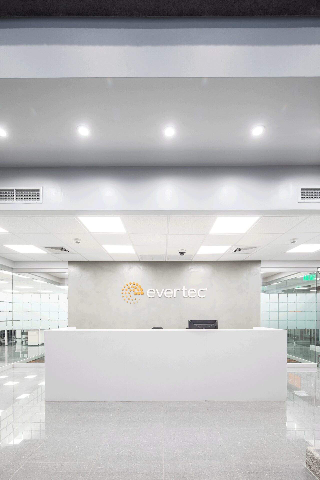 Interior remodelado del edificio Evertec con espacios abiertos, luz natural y galería de arte.