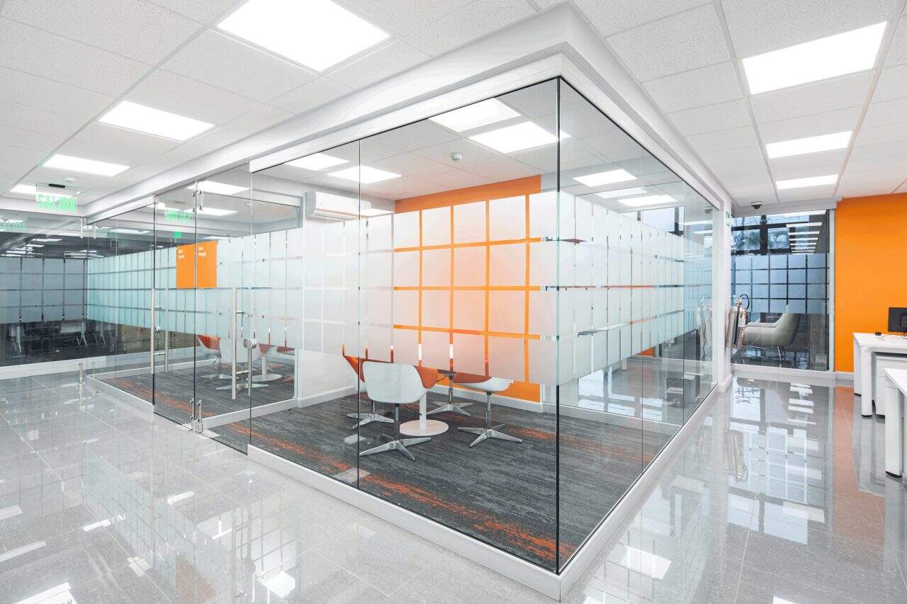 Interior remodelado del edificio Evertec con espacios abiertos, luz natural y galería de arte.