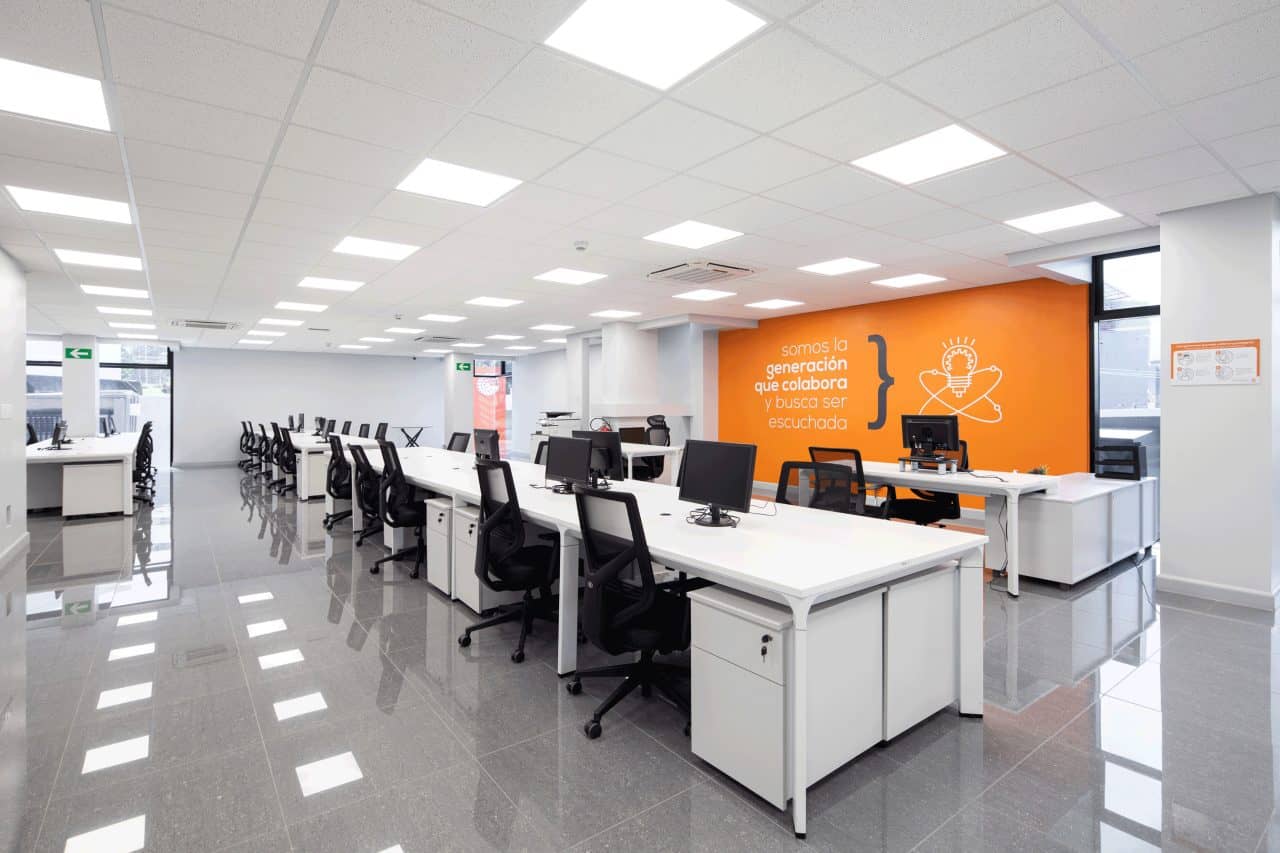 Interior remodelado del edificio Evertec con espacios abiertos, luz natural y galería de arte.