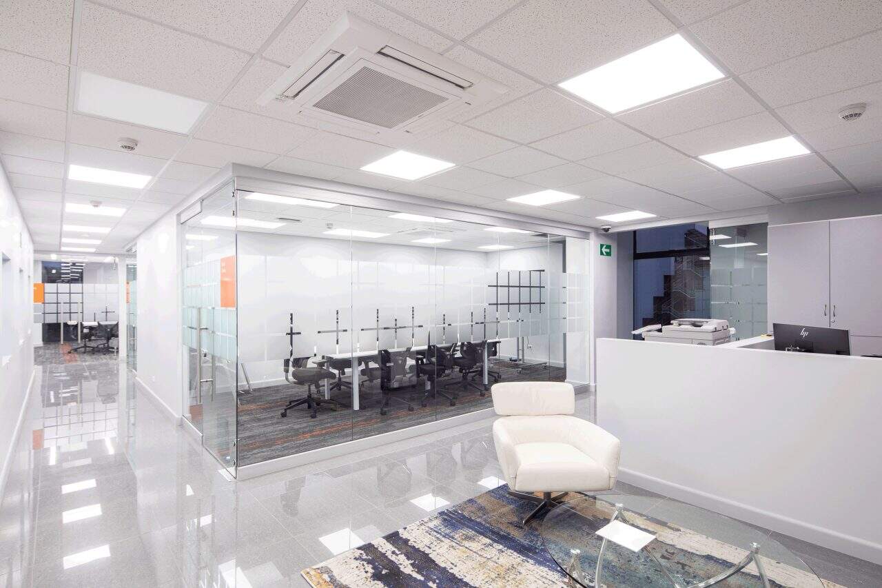 Interior remodelado del edificio Evertec con espacios abiertos, luz natural y galería de arte.