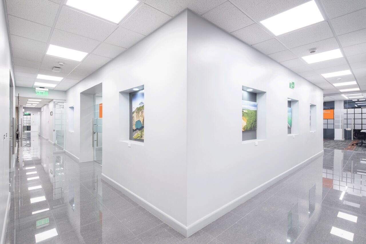 Interior remodelado del edificio Evertec con espacios abiertos, luz natural y galería de arte.