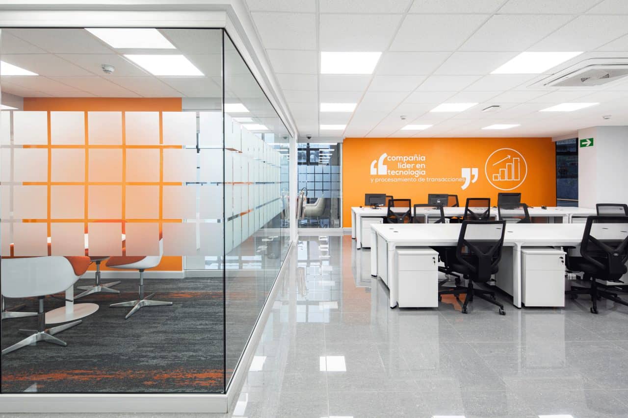 Interior remodelado del edificio Evertec con espacios abiertos, luz natural y galería de arte.