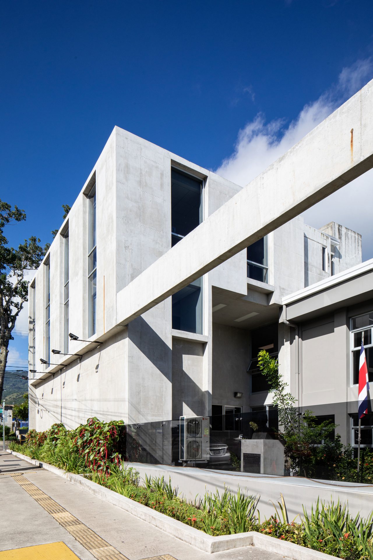 Municipalidad de Santa Ana con patios y jardines que conectan tres edificios históricos mediante diseño sostenible y accesible.