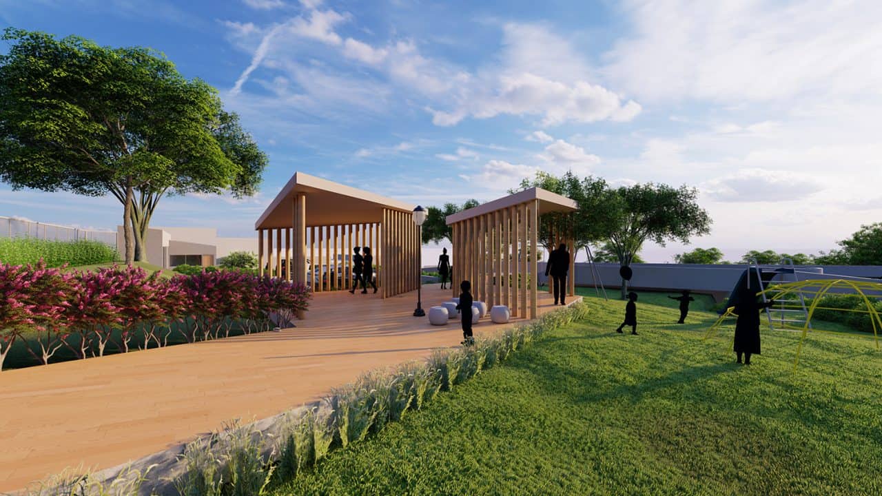 Vista aérea del Parque Pulmón Verde con senderos, jardines y estructuras sostenibles en una ladera boscosa.