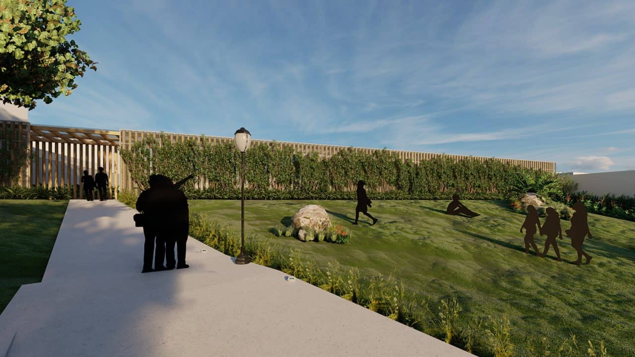 Vista aérea del Parque Pulmón Verde con senderos, jardines y estructuras sostenibles en una ladera boscosa.