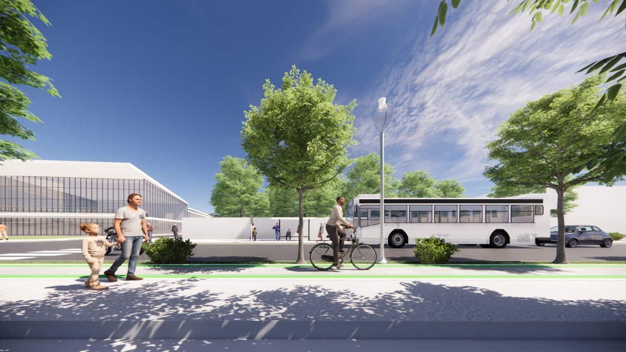 Vista de aceras renovadas y ciclovía en el centro urbano de Santa Ana con arborización y mobiliario urbano.