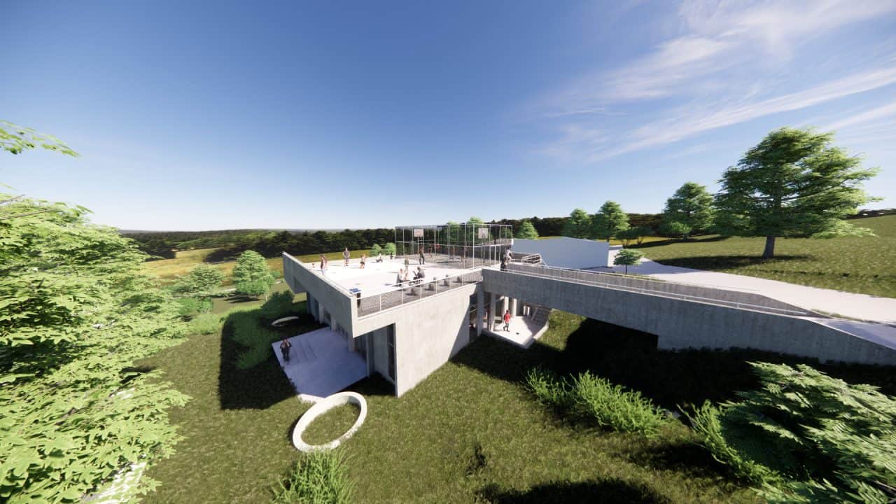 Vista de la plaza superior y puente peatonal del Centro de Desarrollo Humano de Matinilla, integrado al paisaje montañoso.