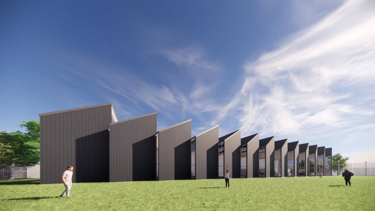 Piscinas Públicas de Grecia con volumen en diente de sierra y luz cenital Vista interior de la piscina semiolímpica con gradería y ventilación cruzada Acceso con plaza, escalera‑anfiteatro y vestíbulo de doble altura Fachada roja de Piscinas Públicas de Grecia iluminada de noche