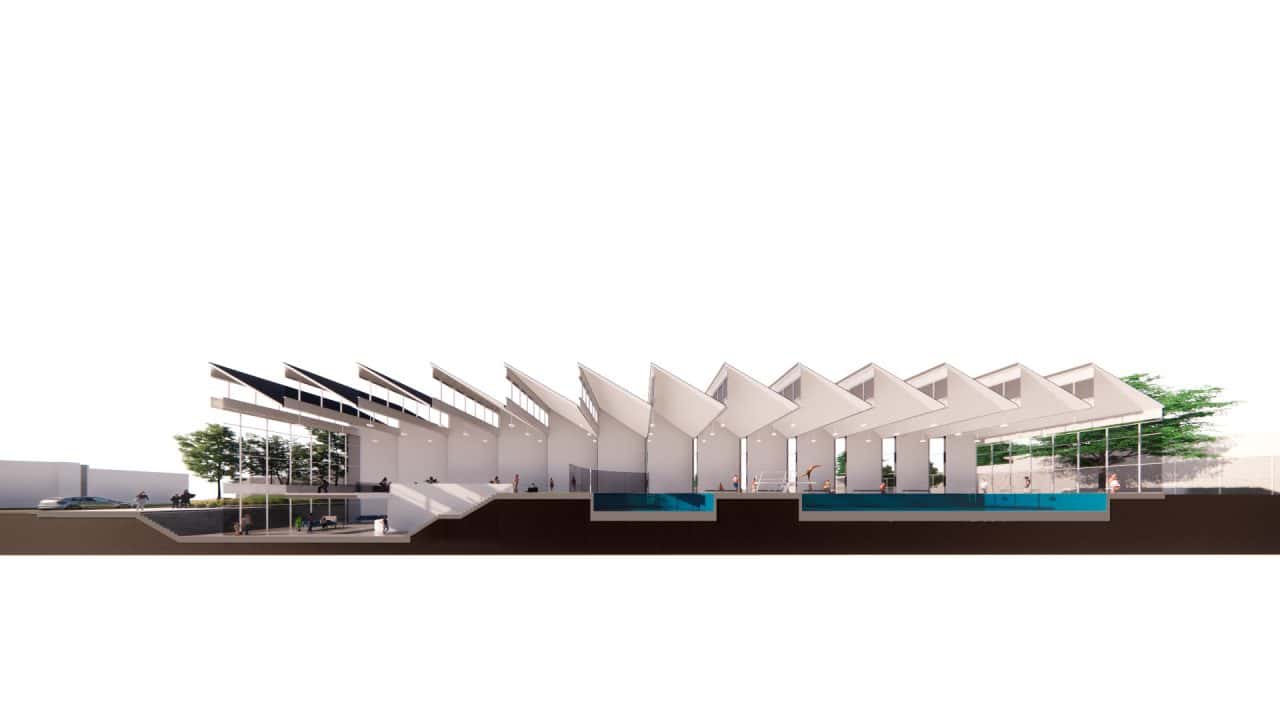 Piscinas Públicas de Grecia con volumen en diente de sierra y luz cenital Vista interior de la piscina semiolímpica con gradería y ventilación cruzada Acceso con plaza, escalera‑anfiteatro y vestíbulo de doble altura Fachada roja de Piscinas Públicas de Grecia iluminada de noche