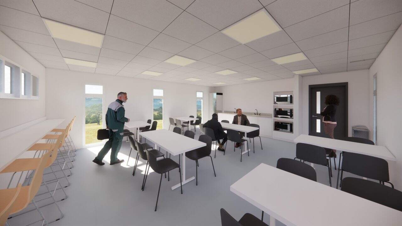 Vista del nuevo volumen en voladizo del plantel municipal de San Carlos con fachada sobria y escalera naranja.